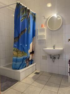 een badkamer met een douchegordijn en een wastafel bij Apartments Silvana in Rogoznica