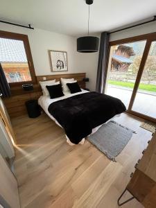 a bedroom with a large bed and a large window at Alpine Creek Chalet Luxury Ski-in in Morzine