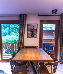 a wooden table in a room with a balcony at Alpine Creek Chalet Luxury Ski-in in Morzine