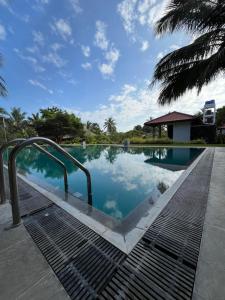 a swimming pool at a resort with a blue sky at NN Beach Resort & SPA in Nilaveli