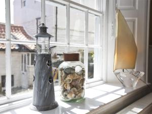 a glass jar with rocks in it sitting on a window sill at 2 Bed in Robin Hoods Bay G0085 in Robin Hood's Bay