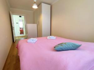 a pink bed with two towels and a pillow on it at Lovely apartment in Küçükyalı in Istanbul