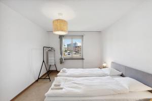two beds in a room with a window at Charming and comfortable Apartment in Zürich