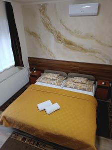 A bed or beds in a room at Boglárka Vendégház