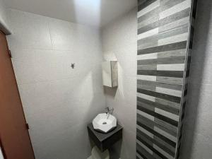 La petite salle de bains est pourvue d'un lavabo et de toilettes. dans l'établissement SHOWMECAS Alley Stay, à Tagbilaran