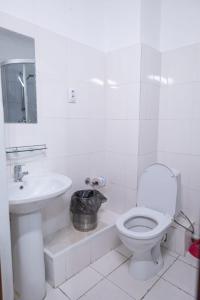 Baño blanco con aseo y lavamanos en Алматы Транзит №1, en Turksib