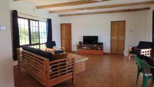 Samburu Dik-Dik House & Susuk Self-catering Cottage في Archers Post: غرفة معيشة مع أريكة وتلفزيون