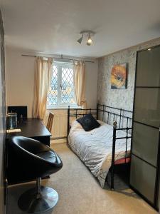 a bedroom with a bed and a desk and a chair at Spacious family home in Malins Lee