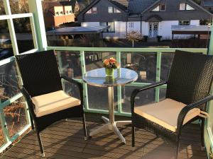 2 chaises et une table sur un balcon dans l'établissement Steiner Strandappartements Appartement 207 Süd- Landseite, à Stein