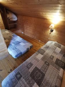 1 dormitorio con 2 camas en una cabaña de madera en La Rose des Vents, en Les Vastres