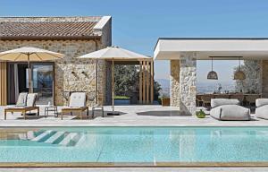 uma piscina com cadeiras e guarda-sóis ao lado de uma casa em Scappo in Umbria, Il Momento em Todi