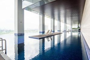 - une piscine avec des chaises dans un bâtiment avec de l'eau dans l'établissement The Azure Residences Kelana Jaya by Airhost, à Petaling Jaya