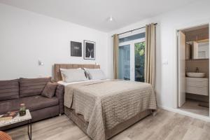 a bedroom with a bed and a couch at Brand new apartments Villa Tereza Icici, 100m from the beach in Ičići