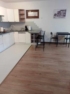 cocina con armarios blancos, mesa y sillas en Apartament Herberta, en Oborniki Śląskie