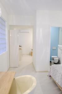 a white bathroom with a tub and a sink at PARASIOU STUDIOS 103 διαμερίσματα στο κέντρο της πόλης in Komotini