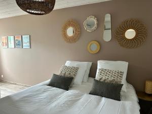 a bedroom with a white bed with pillows and mirrors at Maison 4pers terrasse wifi parking in Talence