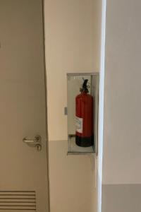 a fire extinguisher in a glass box in a bathroom at OYO 93645 Akasia Budget in Bekasi