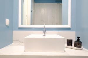 a white sink in a bathroom with a mirror at PARASIOU STUDIOS 102 διαμερίσματα στο κέντρο της πόλης in Komotini