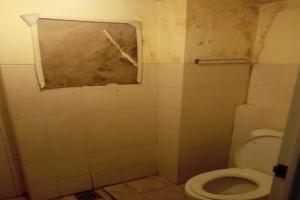 a bathroom with a toilet and a window at OYO 93645 Akasia Budget in Bekasi