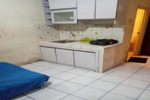 a small kitchen with a sink and a stove at OYO 93645 Akasia Budget in Bekasi