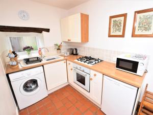 a small kitchen with a washer and dryer at 1 Bed in Curbar PK455 in Curbar