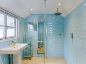 a blue tiled bathroom with a sink and a shower at 3 Bed in Whitstable WCC12 in Whitstable +10 photos
