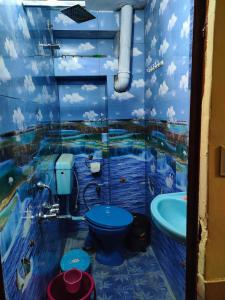 a bathroom with a blue toilet and a bath tub at MOON NIGHT GUEST HOUSE in Jodhpur