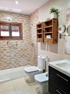 a bathroom with a toilet and a tub and a sink at Beach House Valleniza in Vélez-Málaga