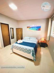 a bedroom with a bed with a blue comforter at Paraíso do Boldró Flat in Fernando de Noronha