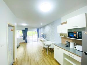 a kitchen with white cabinets and a desk at Townhome in Town in Ban Ba Ngan