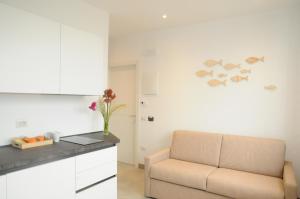 een woonkamer met een bank en een keuken bij House of Oscar in Adria