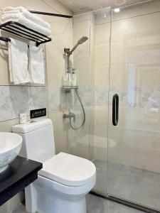 a bathroom with a shower and a toilet and a sink at Hemu House in Fenghuang County