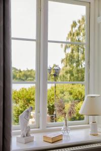 una ventana con una estatua de un pájaro sentada en una mesa en Dallund Slot, en Søndersø