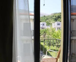 een raam met uitzicht op een balkon met een stoel bij Alexander Mountain Resort in Yerakárion