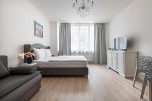 プラハにあるPrague Serenity Suites and Apartmentsのベッドルーム(ベッド1台、ソファ、テレビ付)