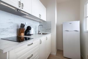 プラハにあるPrague Serenity Suites and Apartmentsの白いキッチン(シンク、冷蔵庫付)
