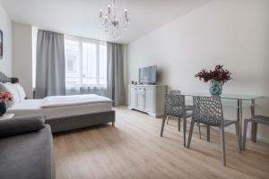プラハにあるPrague Serenity Suites and Apartmentsのリビングルーム(ガラスのテーブル、椅子付)