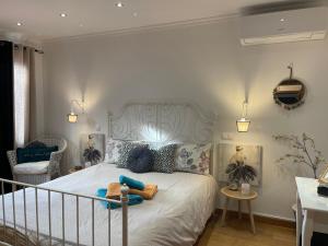 a bedroom with a white bed with blue pillows at Casa dos Avos in Calheta