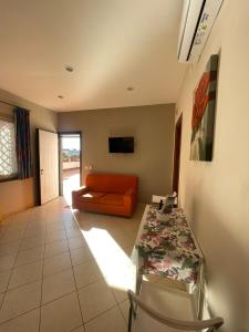 a living room with an orange couch and a table at Villa Aura in Torre del Greco
