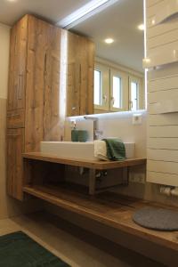 ein Badezimmer mit einem Waschbecken und einem großen Spiegel in der Unterkunft Moderner Schwarzwaldtraum in Oberharmersbach