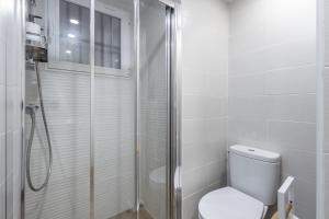 y baño blanco con ducha y aseo. en Suite patio del arquitecto, en Granada