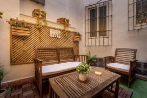 un patio con 2 sillas y una mesa y un edificio en Suite patio del arquitecto, en Granada