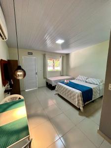 sypialnia z 2 łóżkami i oknem w obiekcie Paraíso do Boldró Flat w mieście Fernando de Noronha