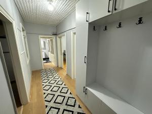 a hallway with white walls and a black and white floor at APARTİST in Istanbul
