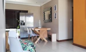 cocina con mesa y nevera de acero inoxidable en Durbanville Luxury Living Private Room, en Durbanville