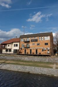 a brick building next to a body of water at RIVA sleep & chill in Valjevo
