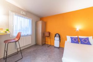グッサンヴィルにあるMontempô apparthôtel CDG Goussainvilleのオレンジ色の壁のベッドルーム1室、ベッド1台、椅子1脚が備わります。