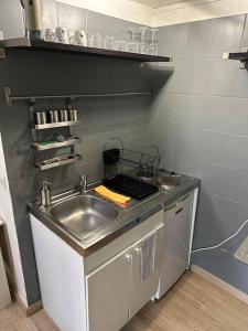 a kitchen with a sink and a counter top at Charmante maisonnette cosy près de Paris in Deuil-la-Barre