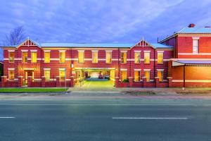 Lake Inn - Ballarat في بالارات: مبنى احمر كبير شبابيكه صفراء وشارع