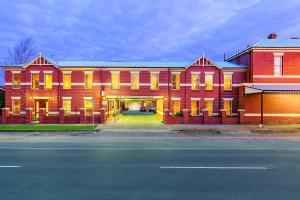 a large red building with yellow windows and a street at Lake Inn - Ballarat in Ballarat